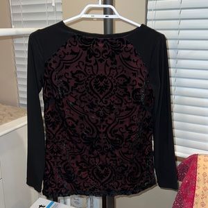 Black long-sleeved blouse with velvet details and red inner layer